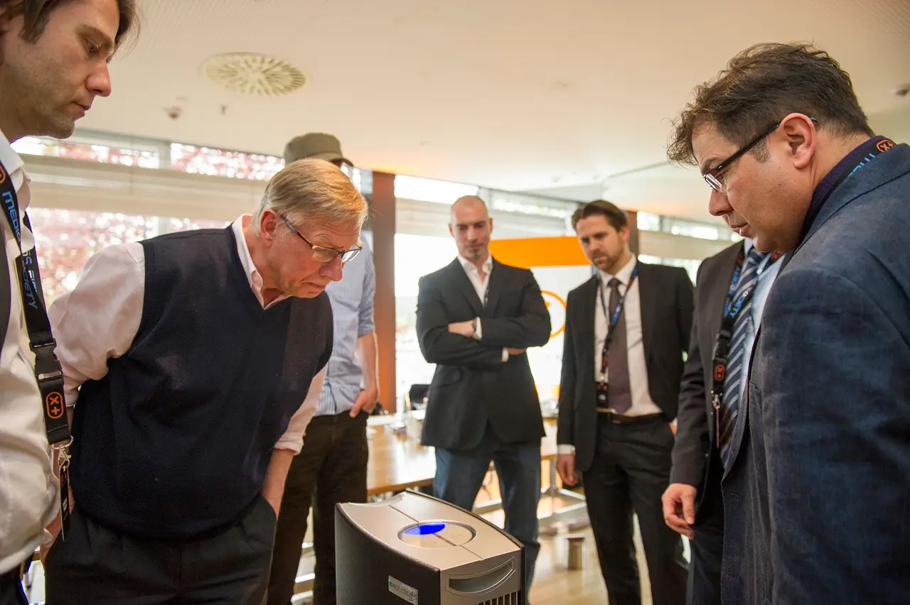 The group leans over a device on the table