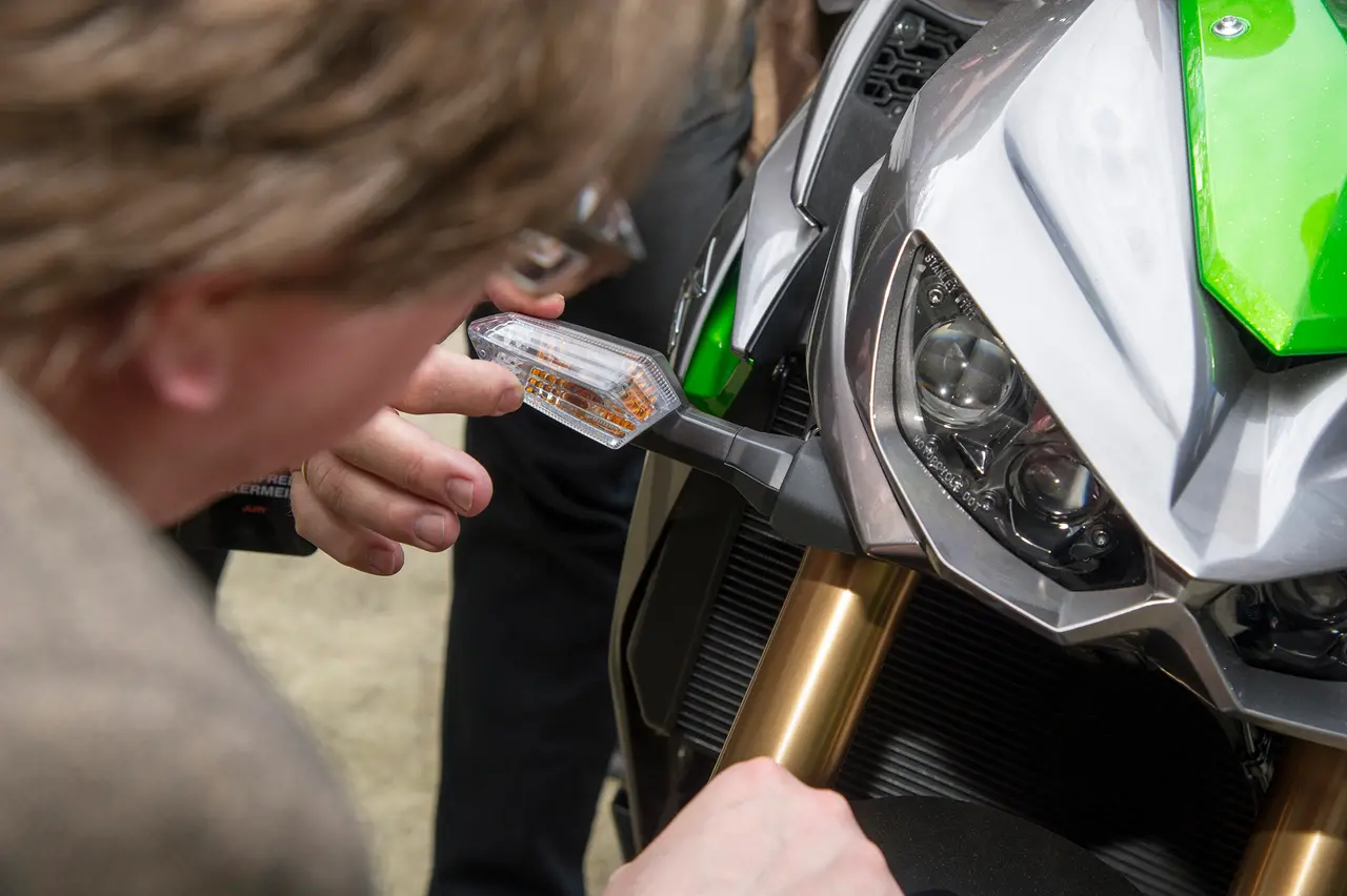 A juror takes a close look at a motorcycle's indicator