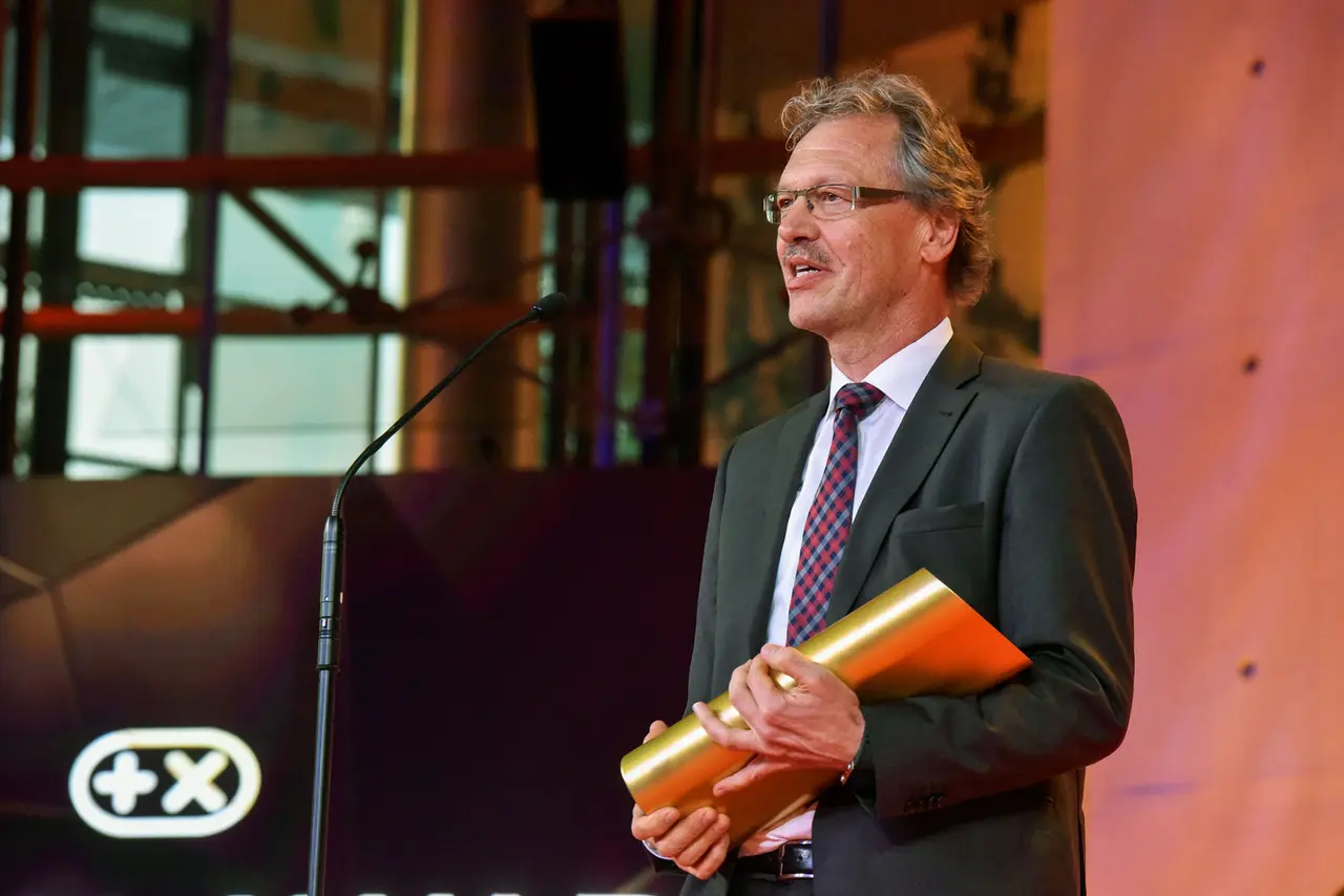 Vertreter des Mercedes-Benz-Entwicklungsteams mit der Trophäe auf der Bühne der Plus X Award Night