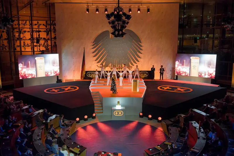 Finale der Plus X Award Night: Sängerin und Tanzensemble auf der Bühne unter dem Bundesadler