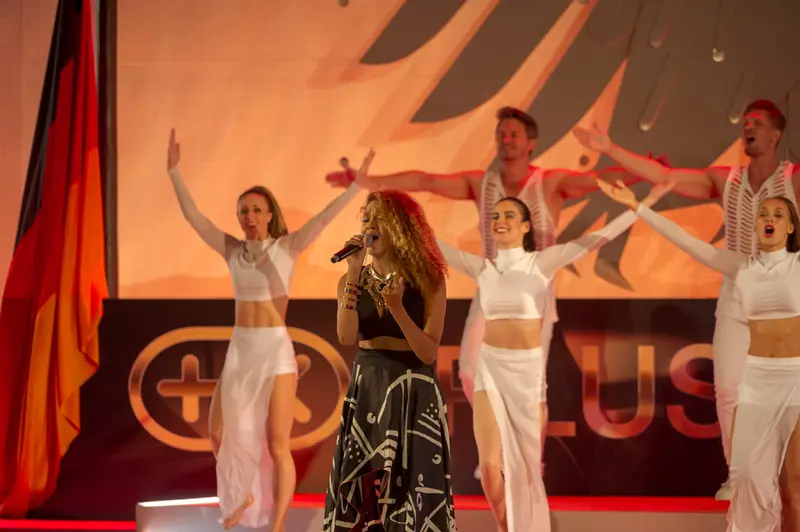 Sängerin mit Tanzensemble bei einem Live-Auftritt auf der Plus X Award Night