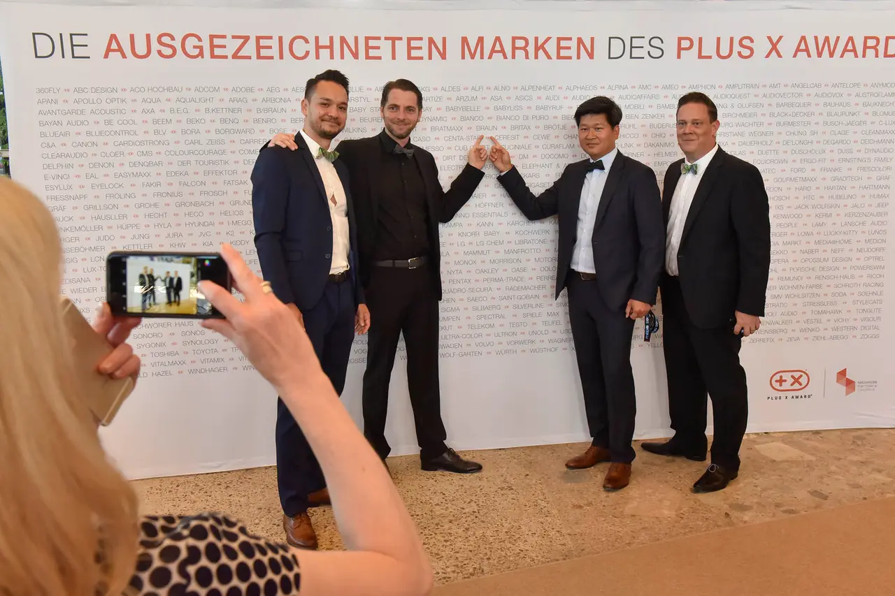 Preisträger vor der Wand der ausgezeichneten Marken