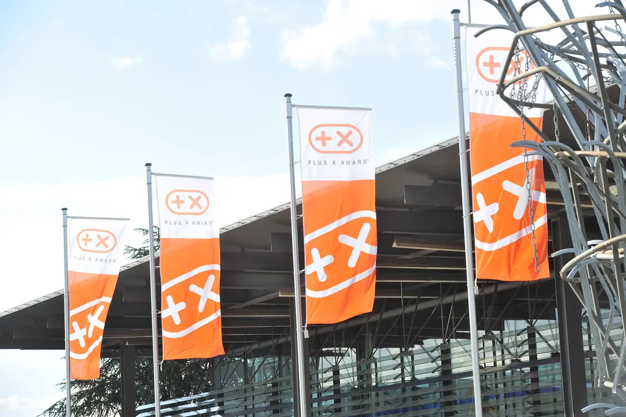 Fahnen mit dem Plus-X-Zeichen vor dem Veranstaltungsort