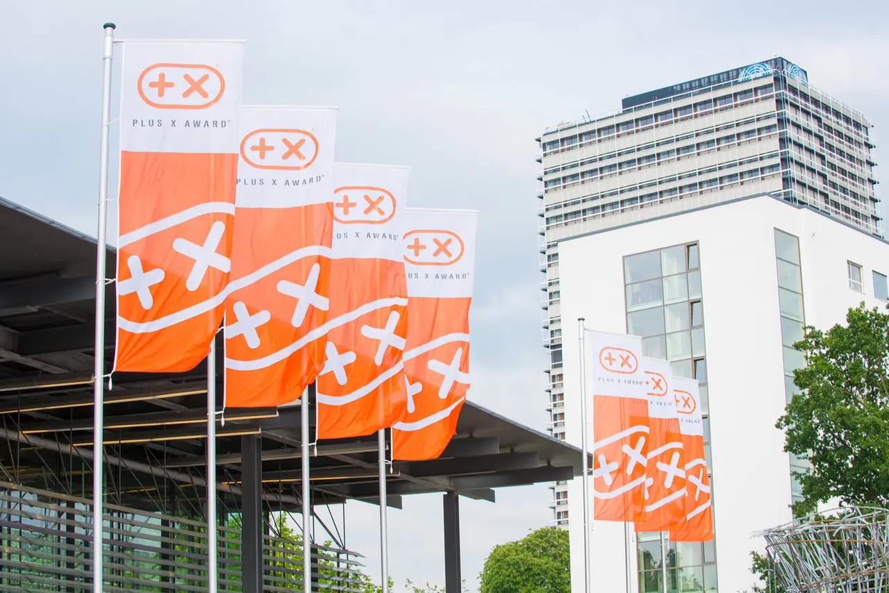 Fahnen mit dem Plus-X-Zeichen vor dem Veranstaltungsort
