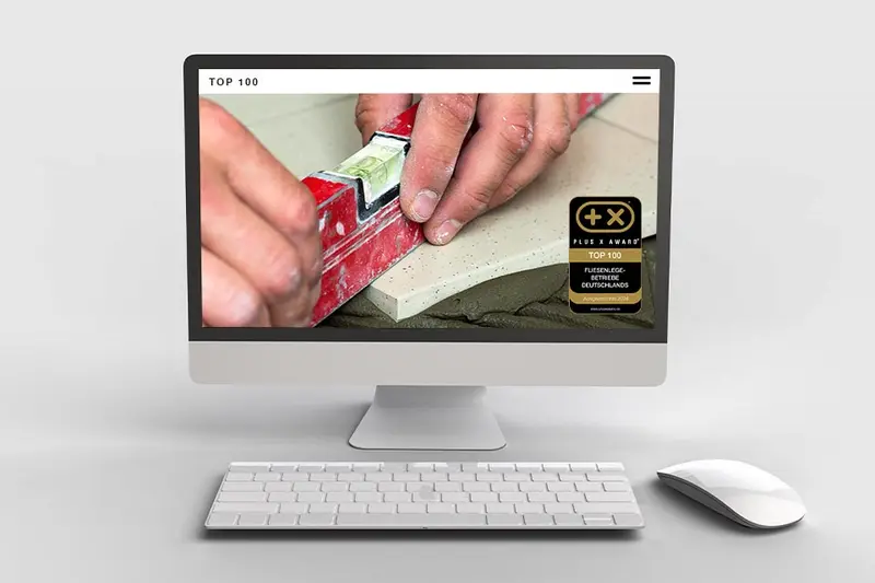 Website mit dem Siegel „Top 100 Fliesenlegebetriebe“ auf einem Bildschirm