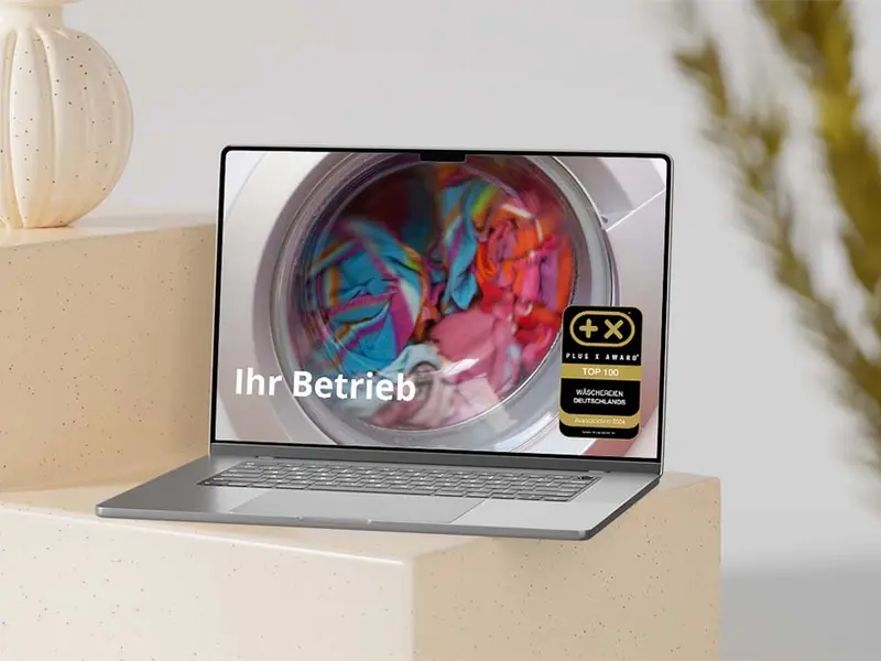 Website mit dem Siegel „Top 100 Wäschereien Deutschlands“ auf einem Bildschirm