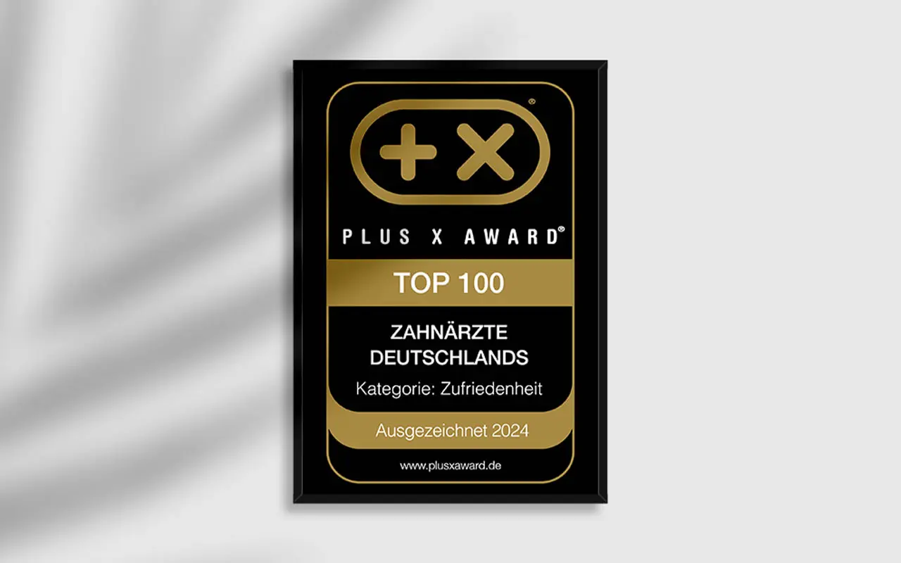 Gerahmtes Siegel „Top 100 Zahnärzte & Kieferorthopäden Deutschlands“ an der Wand